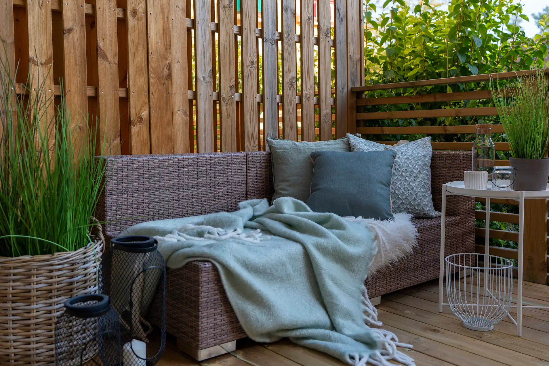 Terrasse mit modernem Holzsichtschutz und Sitzbereich im Garten